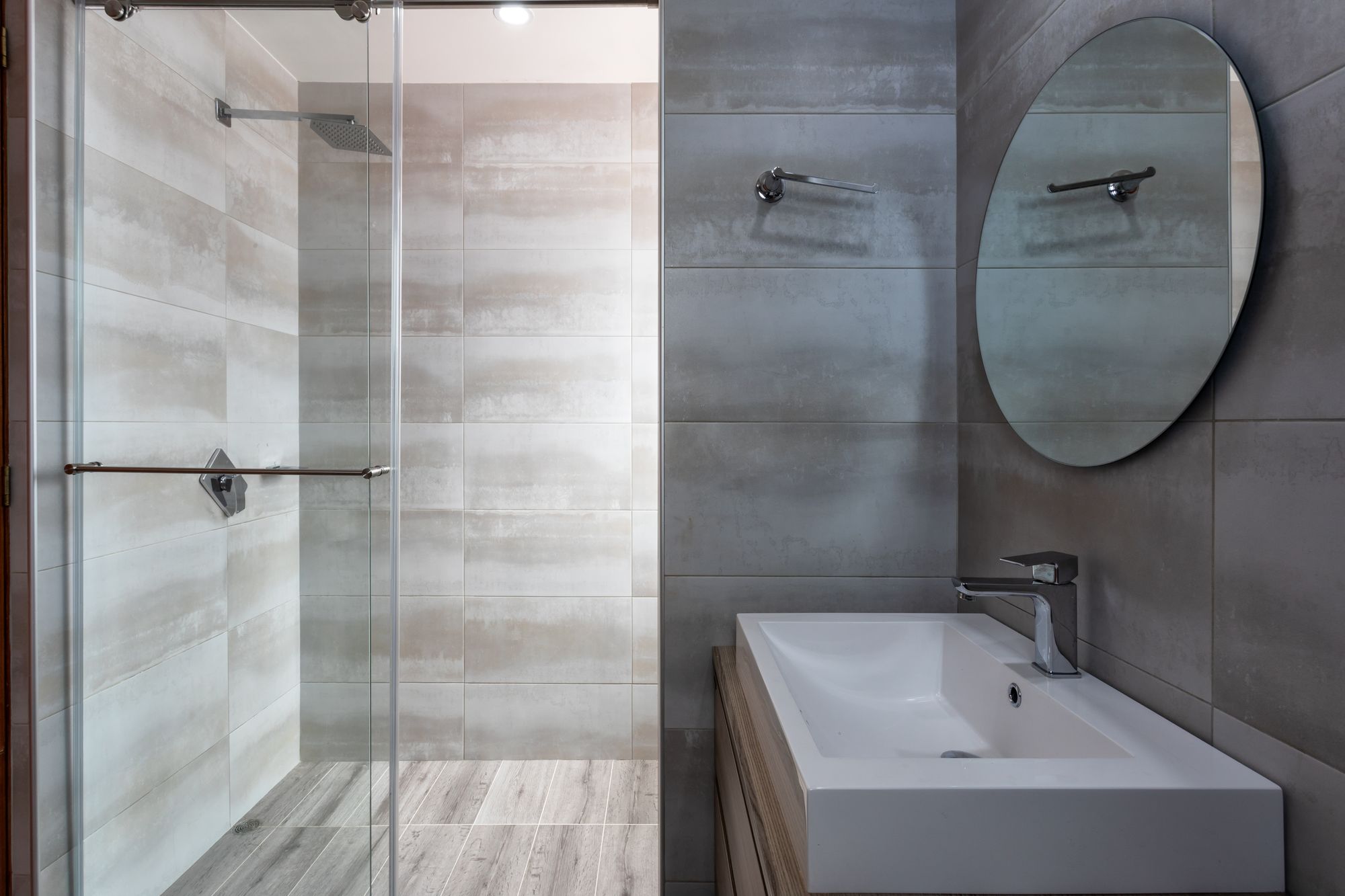 Moderne badkamer met glazen inloopdouche en ronde spiegel